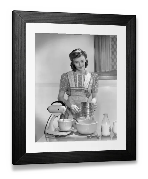Framed Print : Woman In A Apron Over A Cotton Print Dress Sifting Flour In A Bowl Between A Mixer & A Framed Print : Woman In A Apron Over A Cotton Print Dress Sifting Flour In A Bowl Between A Mixer & A