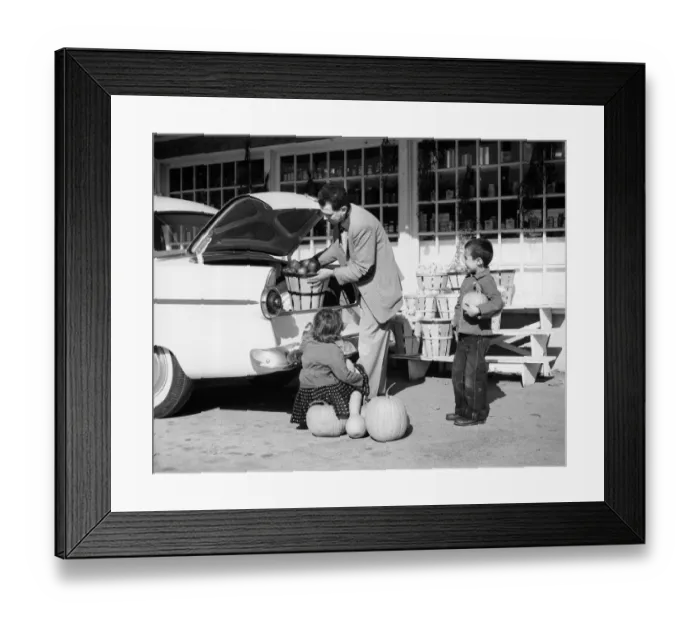 Framed Print : Father loading apples into trunk of car at country market, son and daughter looking Framed Print : Father loading apples into trunk of car at country market, son and daughter looking
