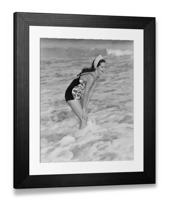 Framed Print : A young woman stands laughing in the surf, circa 1960. (Photo by H Framed Print : A young woman stands laughing in the surf, circa 1960. (Photo by H