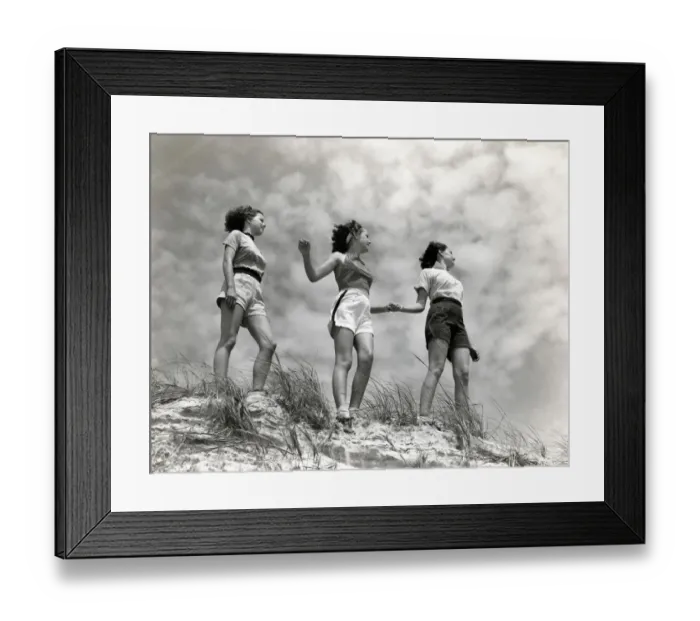 Framed Print : Three women standing on beach, holding hands, smiling. (Photo by H Framed Print : Three women standing on beach, holding hands, smiling. (Photo by H