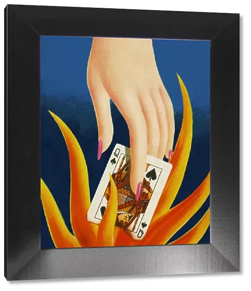 Hand Holding Queen of Spades in a Flame