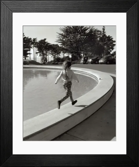 Framed Print : Girl running along edge of fountain Framed Print : Girl running along edge of fountain