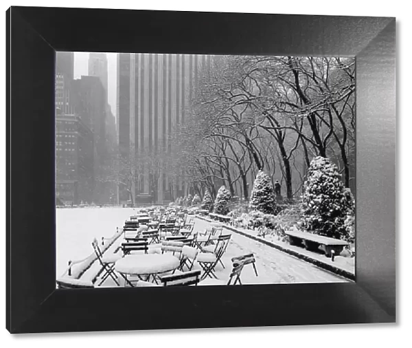 Tables and chairs in park covered with snow, New York City