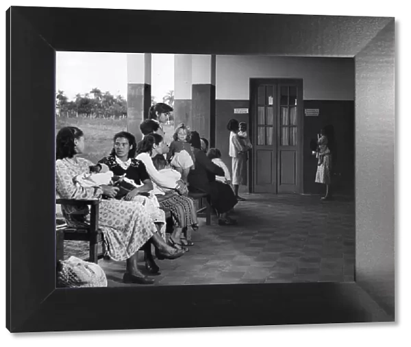 Clinic. circa 1930: Mothers in Paraguay wait with their children for a
