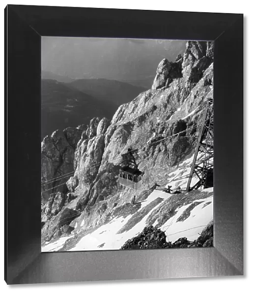 Zugspitze. 1957: A cable car ascending to the top of Zugspitze in the Austrian Tyrol