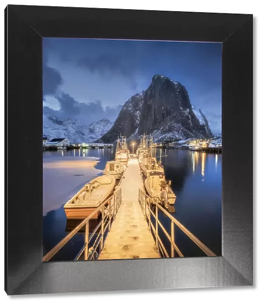 Illuminated landing stage, jetty at the harbour of the fishing village Hamnoy Polar Night