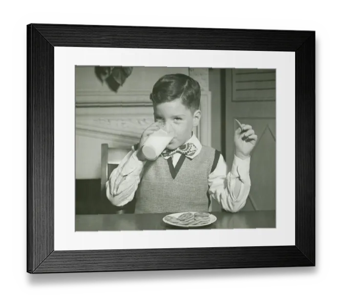 Framed Print : Boy (8-9) drinking glass of milk, sitting at table, (B&W), close-up Framed Print : Boy (8-9) drinking glass of milk, sitting at table, (B&W), close-up