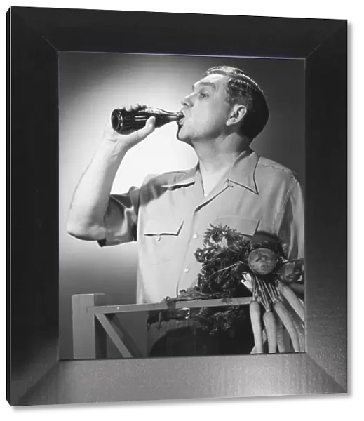 Man drinking cola from bottle in studio (B&W)