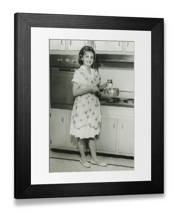 Framed Print : Young woman holding can of soup and pot in kitchen, (B&W) Framed Print : Young woman holding can of soup and pot in kitchen, (B&W)