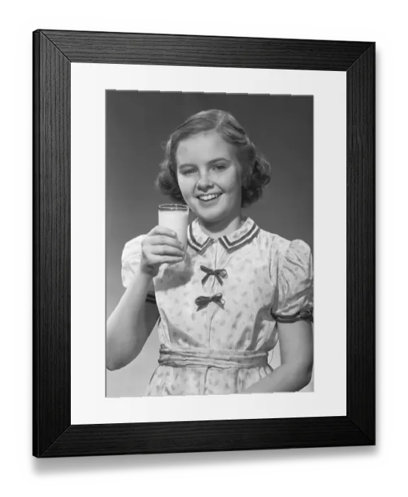 Framed Print : Girl (12-13) posing with glass of milk, (B&W), portrait Framed Print : Girl (12-13) posing with glass of milk, (B&W), portrait