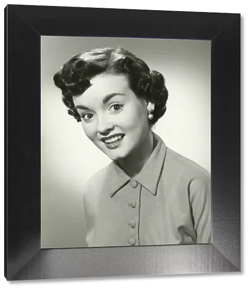 Young woman with short hair smiling, (B&W), portrait