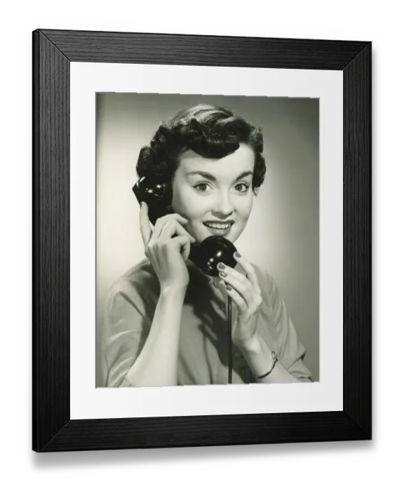 Framed Print : Young woman with short hair holding receiver, (B&W), portrait Framed Print : Young woman with short hair holding receiver, (B&W), portrait