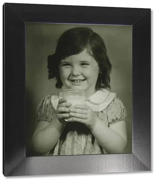 Girl (4-5) holding glass of milk, (B&W), portrait