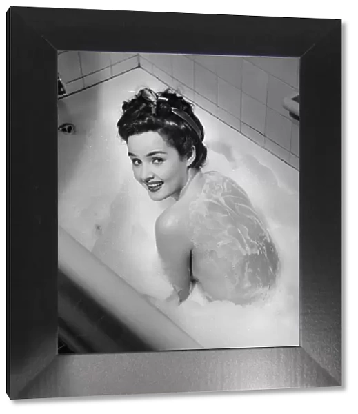 Woman taking bubble bath, (B&W), elevated view
