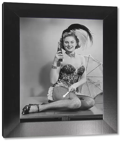 Woman in corsets and fancy hat posing in studio (B&W), portrait