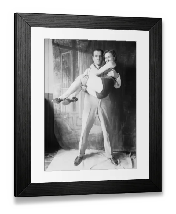 Framed Print : My Hero. circa 1930: The stern hero in collar and tie carries off the swimsuited heroine