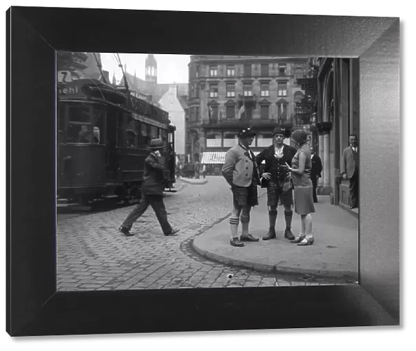 Bavarians. circa 1930: A fashionable woman talks to a couple of men in