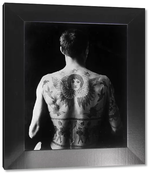 Tattoos. circa 1930: A mans back tattooed with cherubs and dancing girls