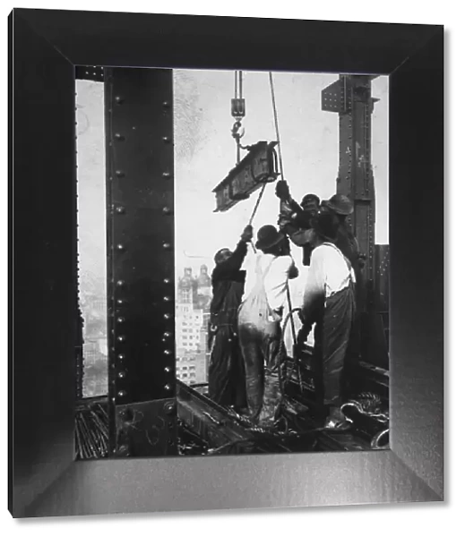Manpower. circa 1930: A group of men hauling a girder up into a skyscraper
