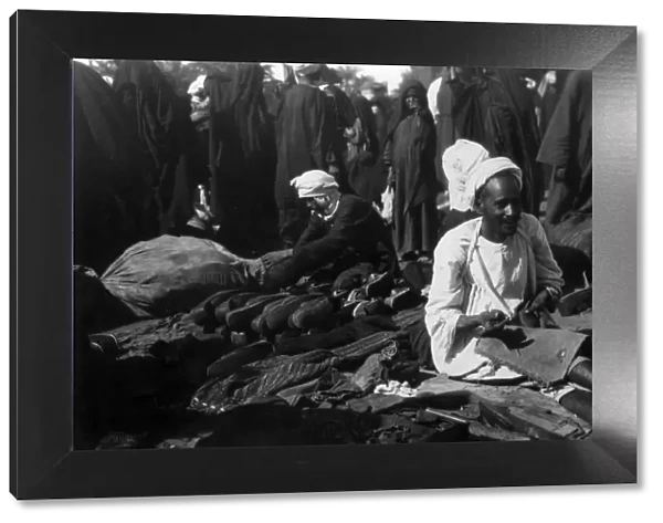 Shoemaker. circa 1930: An Egyptian shoe maker plies his trade in the marketplace