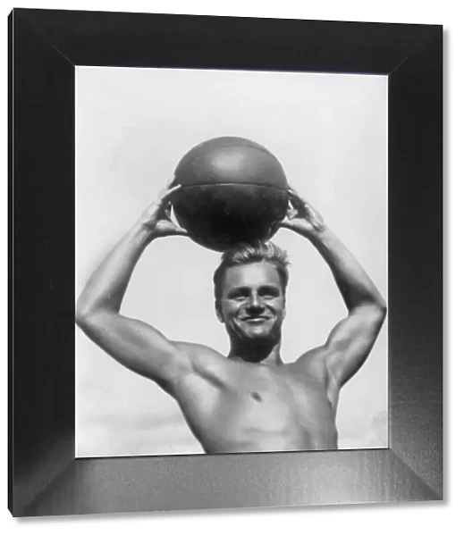 Atlas. circa 1930: A German athlete poses with a beach ball