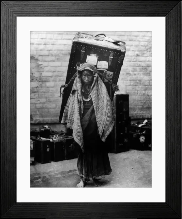 Framed Print : Burdened. circa 1930: A poor Kashmiri woman carrying a trunk as large as