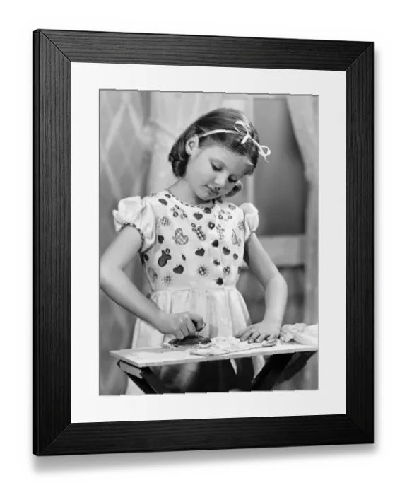 Framed Print : Girl (7-9) using toy iron (B&W) Framed Print : Girl (7-9) using toy iron (B&W)