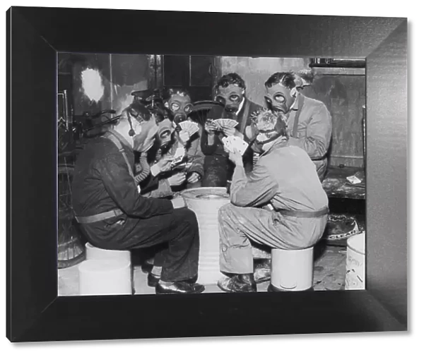 Group of men playing cards, wearing gas masks (B&W)