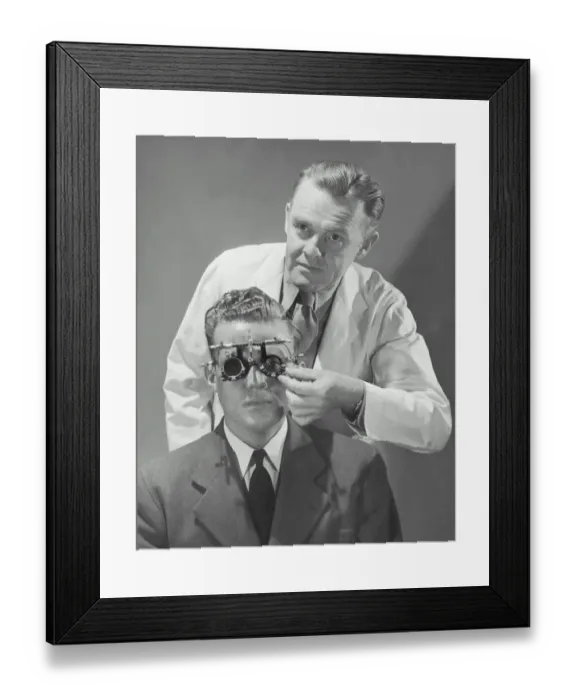 Framed Print : Optometrist giving man eye examination (B&W) Framed Print : Optometrist giving man eye examination (B&W)