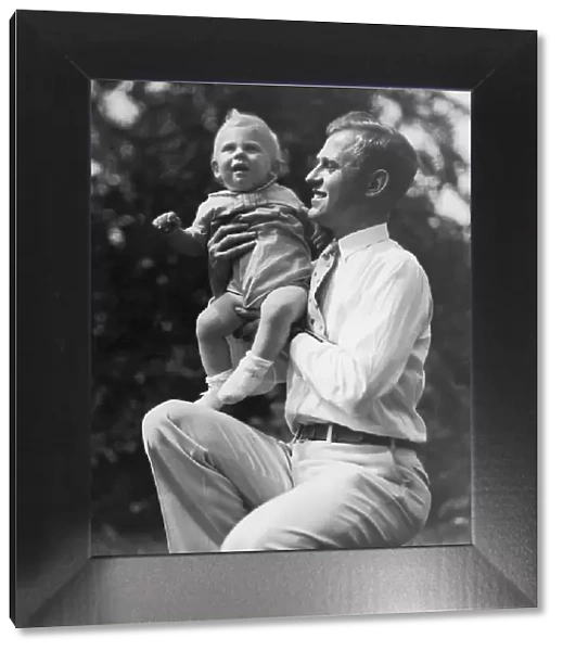 Father holding toddler boy (15-18 months) outdoors (B&W)
