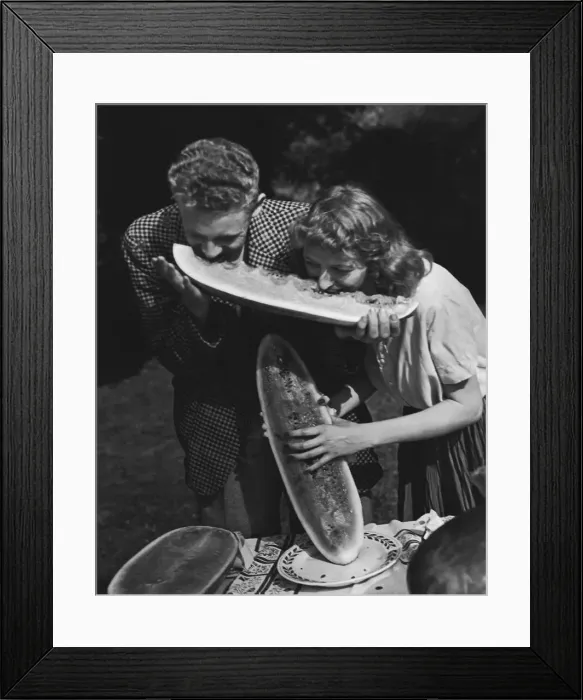 Framed Print : Young couple sharing wedge of watermelon (B&W) Framed Print : Young couple sharing wedge of watermelon (B&W)