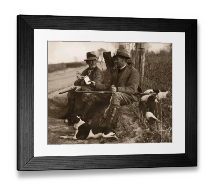 Framed Print : Two hunters with dogs sharing cigars (B&W sepia tone)