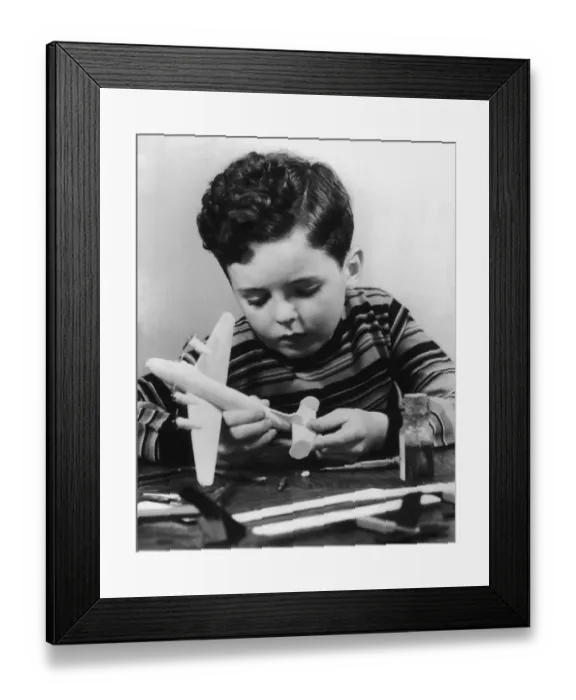 Framed Print : Boy (7-9) building model airplane (B&W) Framed Print : Boy (7-9) building model airplane (B&W)