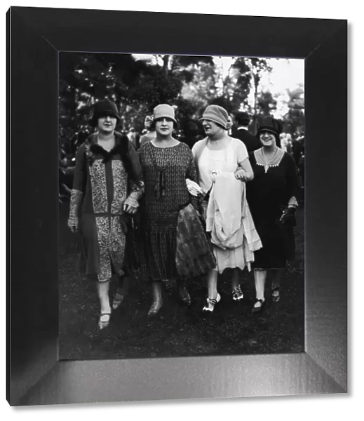 Four women walking arm in arm (B&W)
