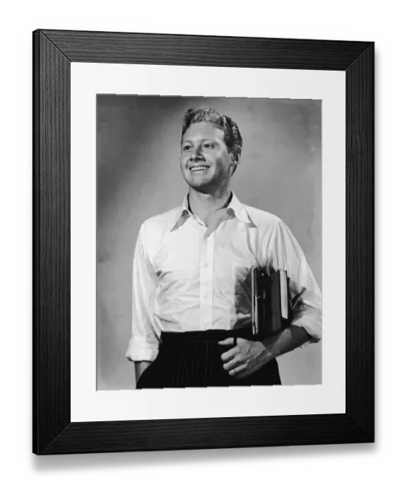Framed Print : Young man with books under arm smiling (B&W) Framed Print : Young man with books under arm smiling (B&W)