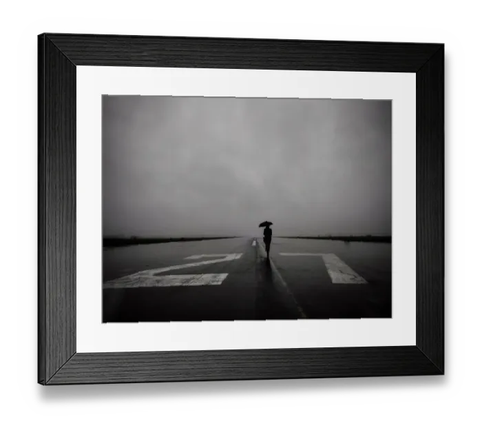 Framed Print : Lone woman with umbrella on empty runway 27 left at Tempelhof Airport in Berlin on a rainy day Framed Print : Lone woman with umbrella on empty runway 27 left at Tempelhof Airport in Berlin on a rainy day