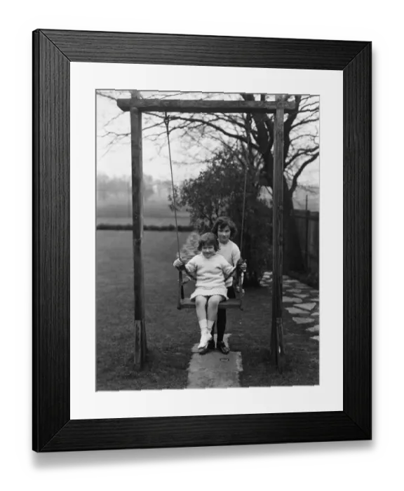 Framed Print : Swing Fun. circa 1930: Two children playing with a swing