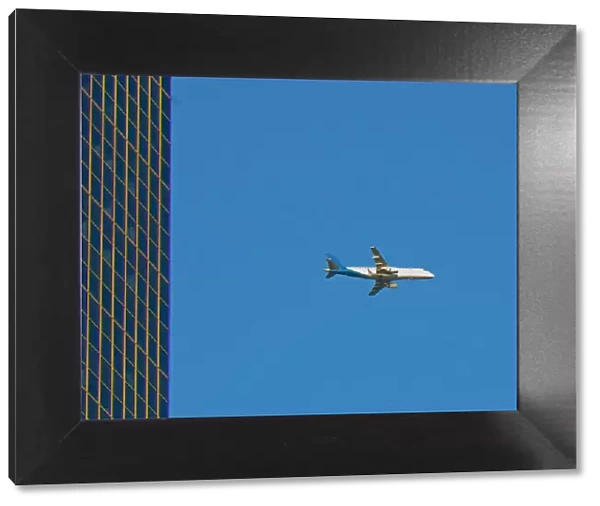 Flyby. A color photograph of a commercial passenger jet flying past a commercial