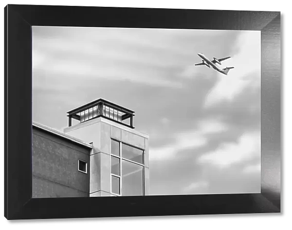 Flyover. A black and white photograph of a commercial aircraft flying over