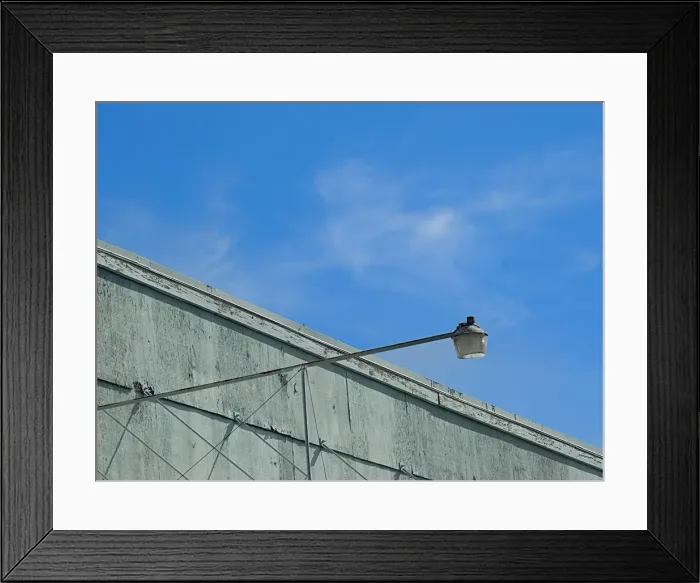 Framed Print : Sky Light. A color photo of a security light on an aging commercial building in Portland Framed Print : Sky Light. A color photo of a security light on an aging commercial building in Portland