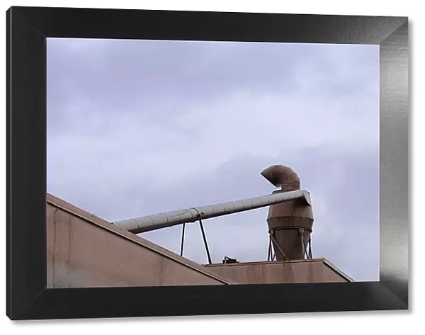 Hopper. A color photo of an industrial ventilation turbine on the roof