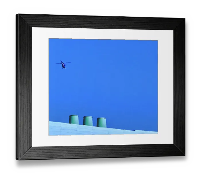 Framed Print : Sortie. A color photo of a helicopter flying over a commercial building Framed Print : Sortie. A color photo of a helicopter flying over a commercial building