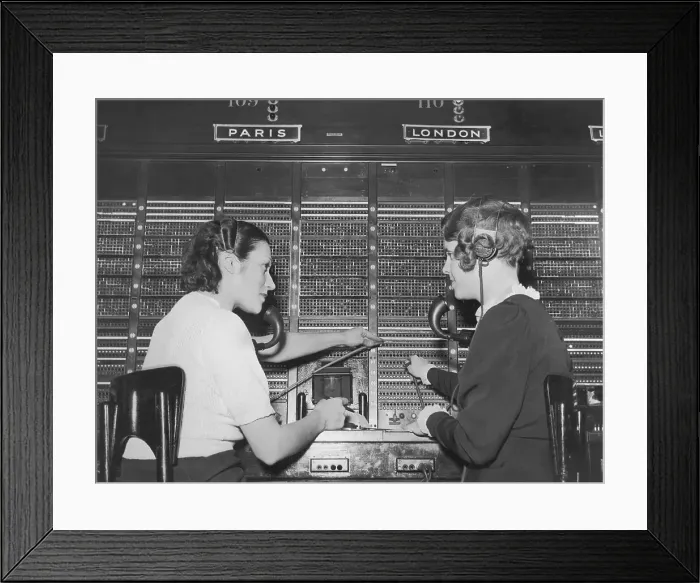 Framed Print : Two female switchboard operators connecting international calls (B&W) Framed Print : Two female switchboard operators connecting international calls (B&W)