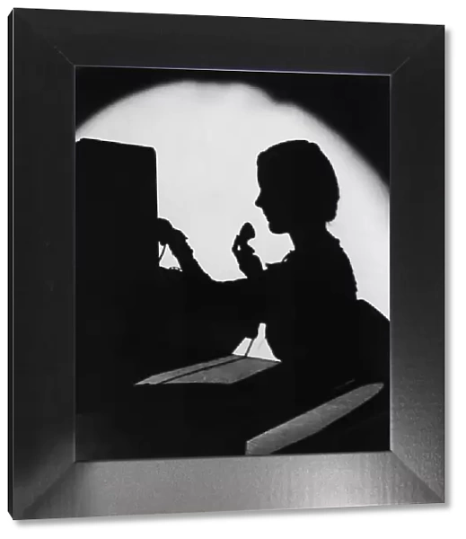 ARCHIVE SHOT  /  SILHOUETTE OF SWITCHBOARD OPERATOR  /  INDOORS