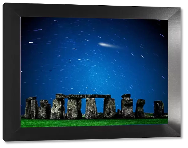 The prehistoric Stonehenge Monument on the Salisbury Plain, UK with time-exposure of star trails and comet in the sky