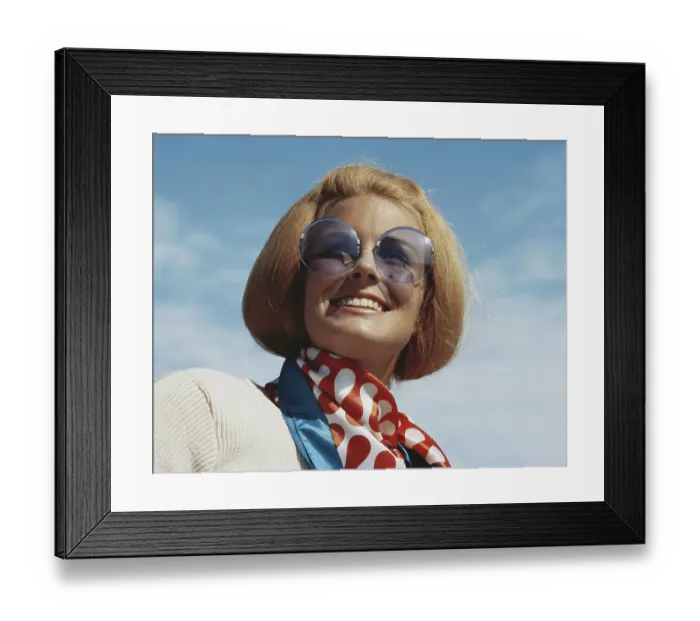 Framed Print : Young woman wearing sunglasses, smiling, close-up Framed Print : Young woman wearing sunglasses, smiling, close-up