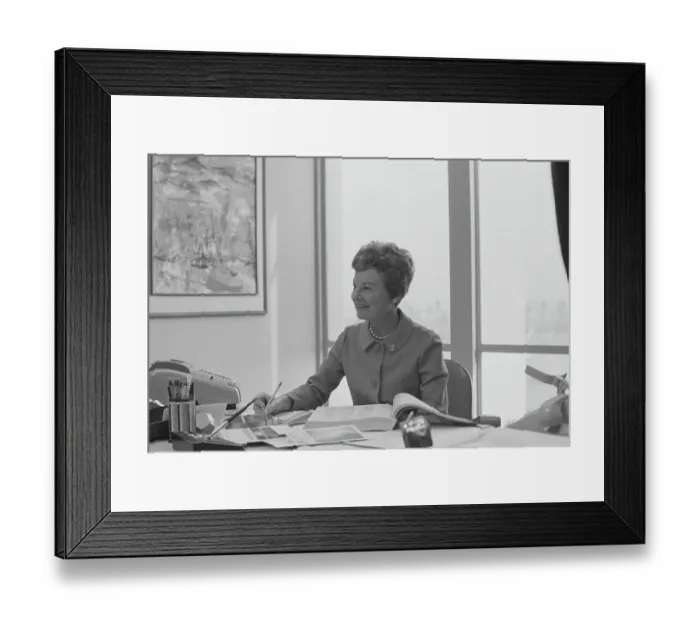 Framed Print : Senior woman sitting at desk writing on notepad, smiling Framed Print : Senior woman sitting at desk writing on notepad, smiling