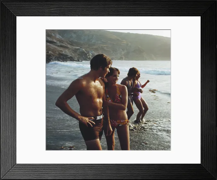 Framed Print : Young couples standing on beach, smiling
