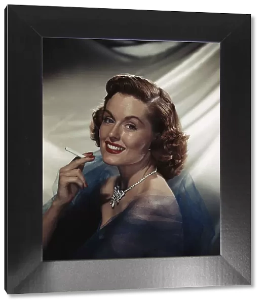 Woman holding cigarette, smiling, portrait