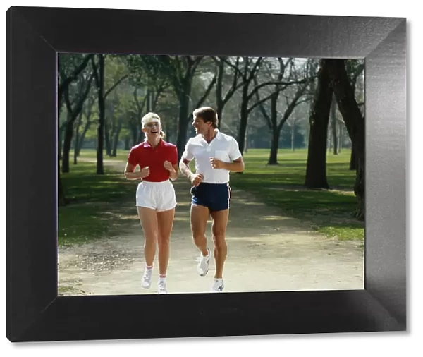 Couple jogging in park, smiling